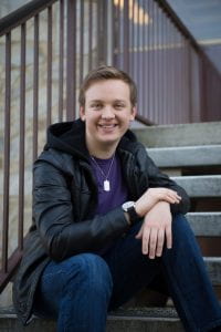 Nathanael Heisler posing on the exterior steps of the Vasche Library at CSU Stanislaus